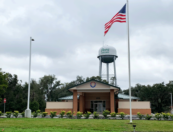 Image of Perry Building with flag pole and Perry Water tower